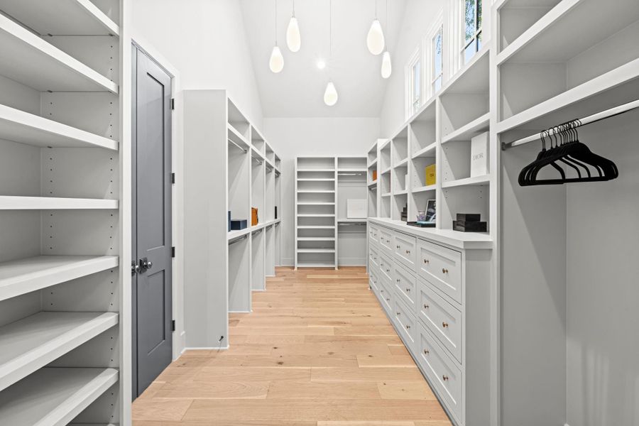 Primary closet with vaulted ceiling and dramatic lighting Primary closet with vaulted ceiling and dramatic lighting