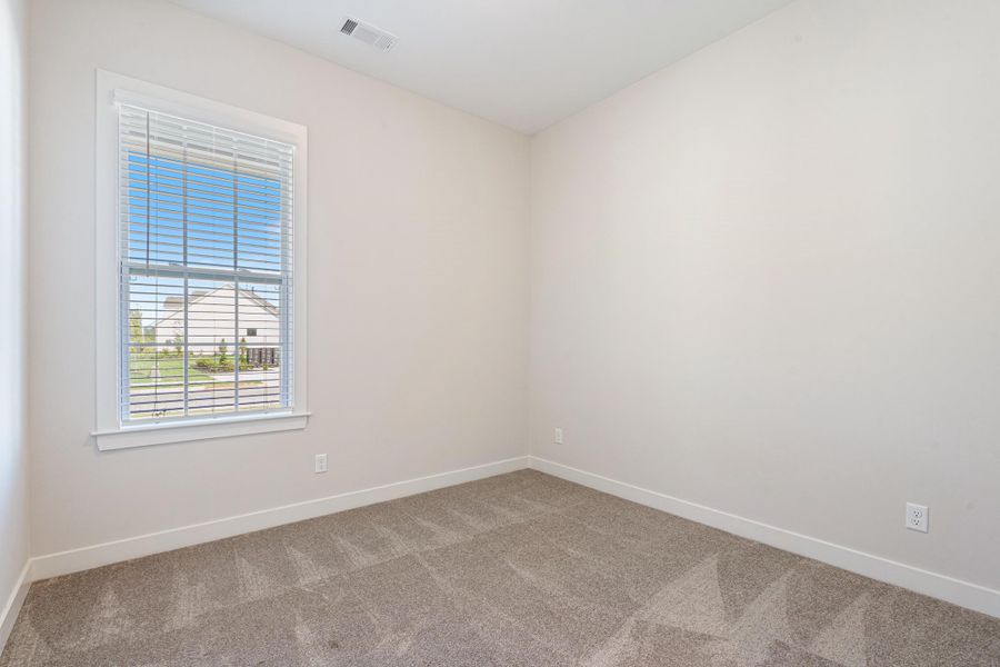 Neutral wall finishes, single window with blinds, and light-toned carpeting Neutral wall finishes, single window with blinds, and light-toned carpeting