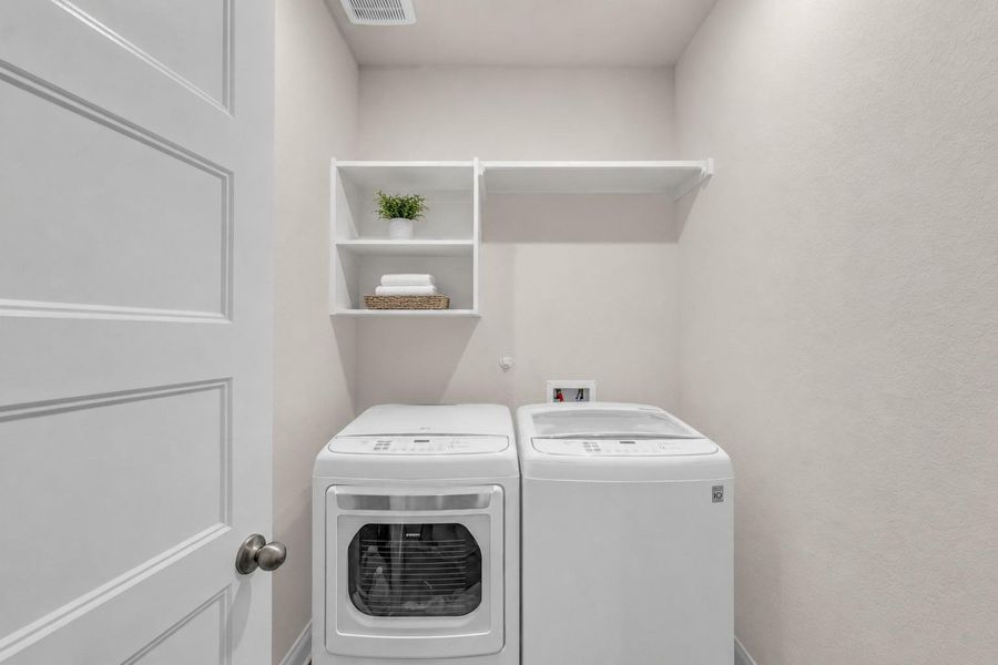 The dedicated laundry room comes complete with integrated storage shelving and hookups situated behind a classic paneled door. The dedicated laundry room comes complete with integrated storage shelving and hookups situated behind a classic paneled door.