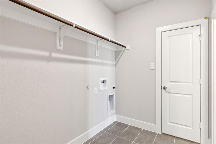 Washroom featuring hookup for a gas dryer, tile patterned flooring, washer hookup, and hookup for an electric dryer Washroom featuring hookup for a gas dryer, tile patterned flooring, washer hookup, and hookup for an electric dryer
