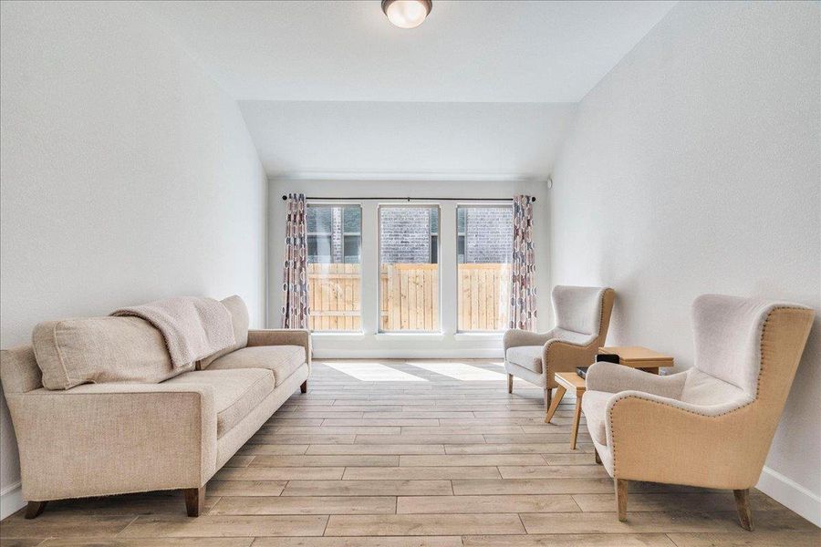 Living area with lofted ceiling and light wood-style floors