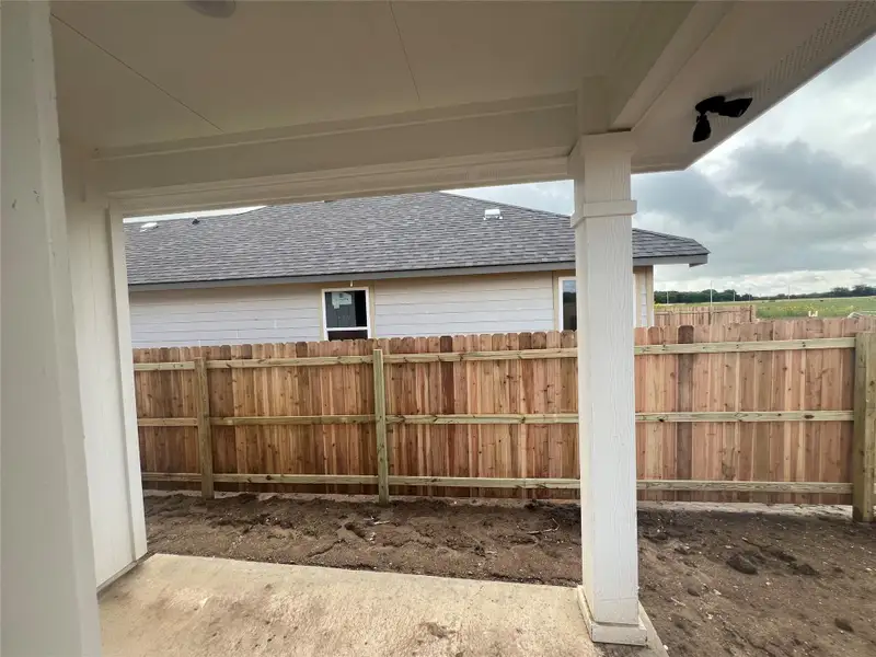 A newly installed wooden privacy fence encloses the outdoor living area.