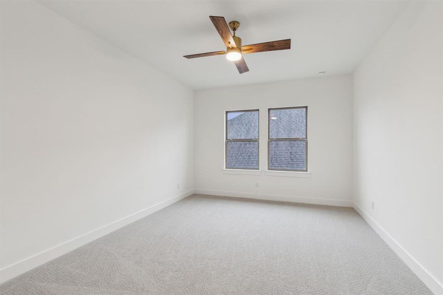 Empty room featuring ceiling fan and carpet