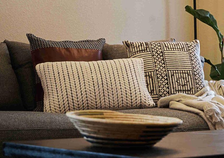 Living room with a comfortable gray couch with decorative pillows, a wood coffee table, and French doors leading to the back patio.