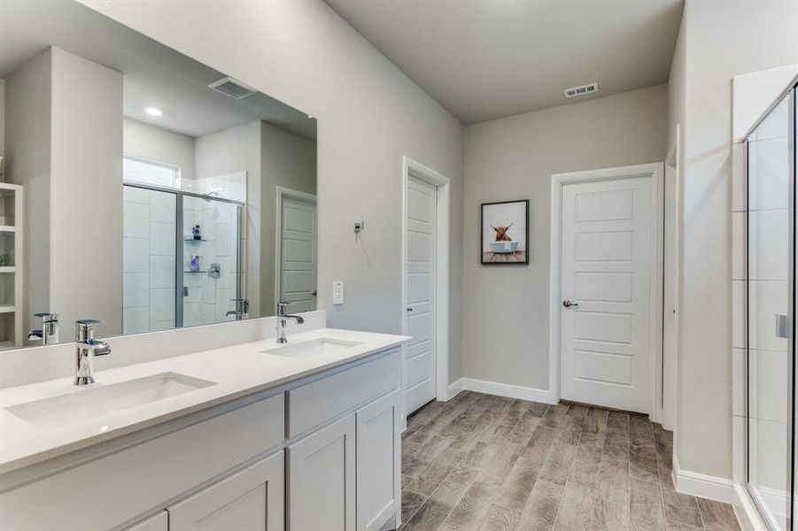 Bathroom featuring vanity, hardwood / wood-style flooring, and a shower with shower door