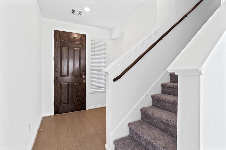 Step inside your new home, where the Bandera Earthy Taupe vinyl plank flooring and fresh, bright paint create a warm and inviting entryway.