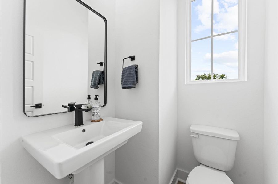 Tucked just off the main living area, this stylishly appointed powder room offers both convenience and privacy. Nestled in a quiet nook, it’s easily accessible for guests yet thoughtfully positioned to maintain separation from the social space.