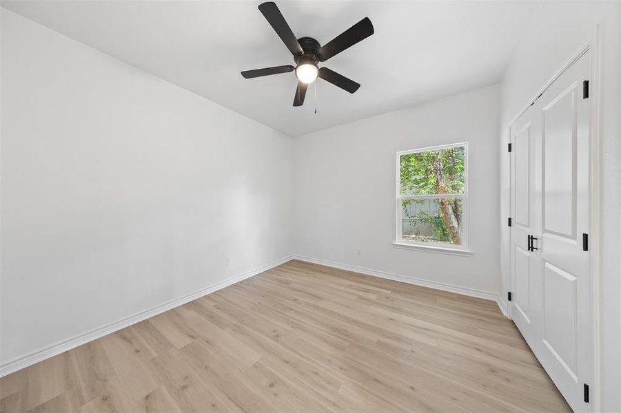 Unfurnished bedroom with light wood finished floors and ceiling fan