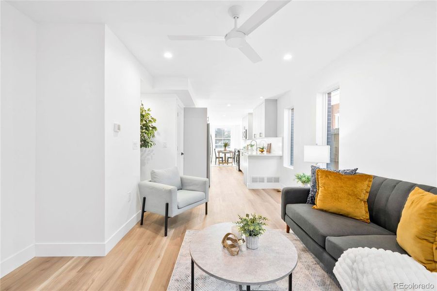Bright and airy living space features warm wood floors and a seamless connection to the kitchen.