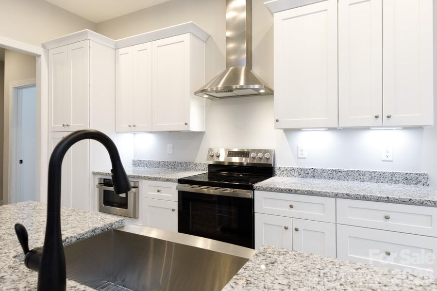 Farmhouse style sink and metal chimney style vent hood. Farmhouse style sink and metal chimney style vent hood.