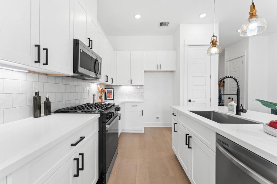 Anchored by a spacious island with bar seating, the kitchen boasts sleek cabinetry, stainless steel appliances, and quartz countertops. The adjoining dining area offers ample room for gatherings, while the sunlit living room invites relaxation with its cozy layout and large windows. Perfect for entertaining or everyday living, this seamless layout blends style and functionality in one stunning space.