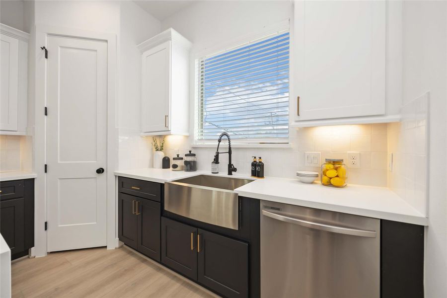 Kitchen with large farmhouse sink & stainless steel appliances. Photo of the model home. Finishes & specifications may vary.