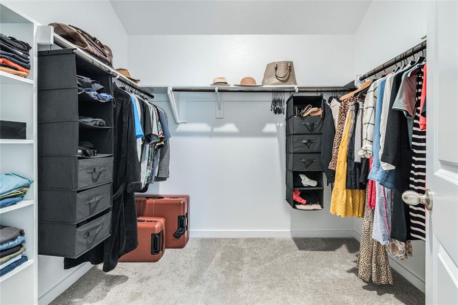 Large walk in primary closet boast built in shelving and plenty of storage space.