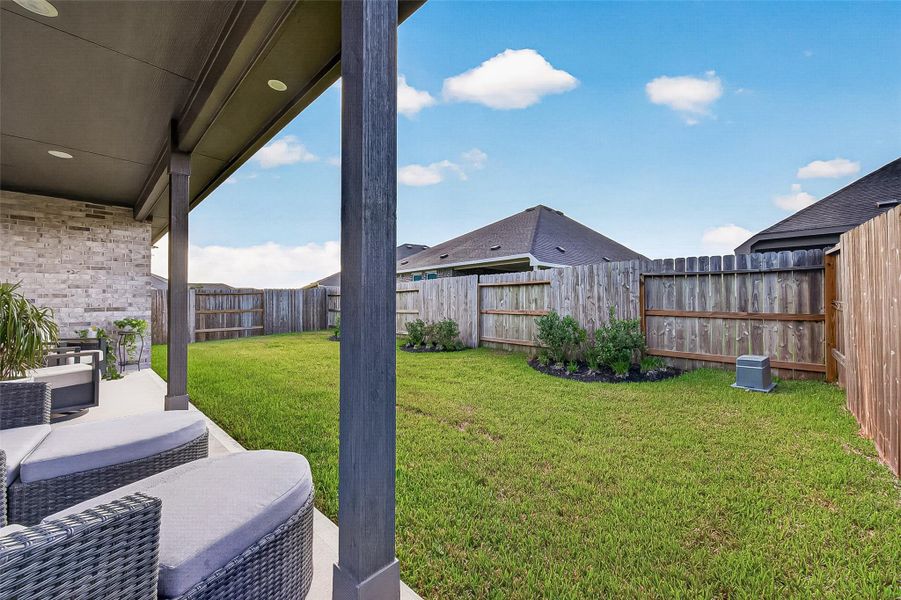 Covered patio overlooking the fenced backyard. Covered patio overlooking the fenced backyard.