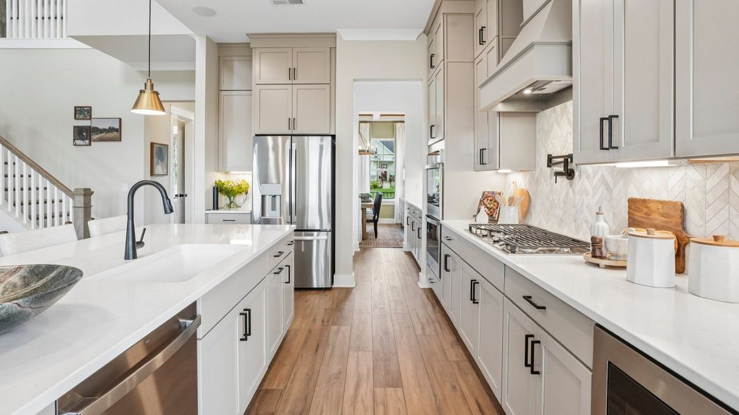 Kitchen with quartz countertops, tile backsplash, and pendant lighting Kitchen with quartz countertops, tile backsplash, and pendant lighting