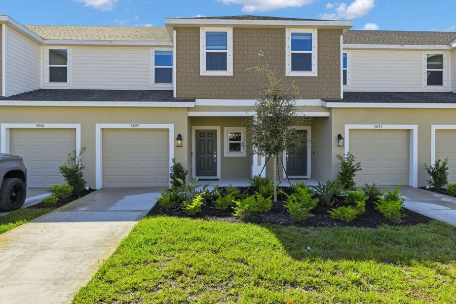 Front exterior of a new home in Vinterra Townhomes, Nokomis, FL, highlighting curb appeal (Image 1).