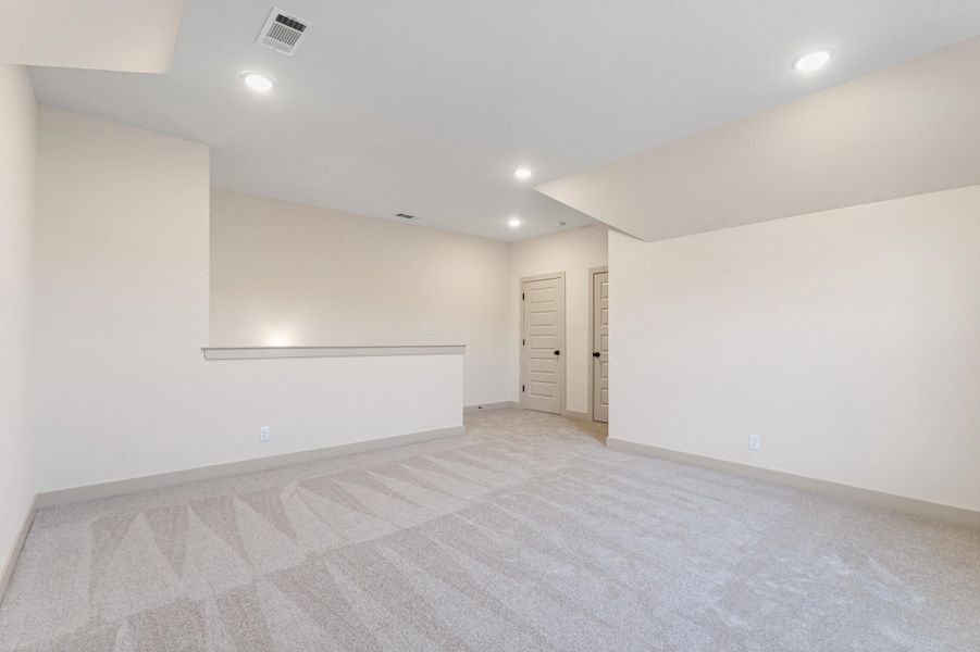 Spare room with light colored carpet and recessed lighting