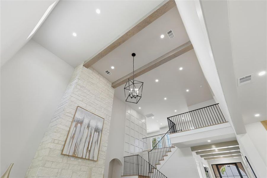 Dramatic volume ceilings with exposed wood beams, statement lantern, and open-rail staircase Dramatic volume ceilings with exposed wood beams, statement lantern, and open-rail staircase
