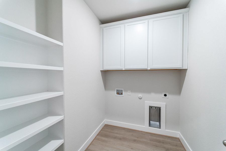 Laundry room with hookup for a gas dryer, hookup for a washing machine, light wood-style floors, hookup for an electric dryer, and cabinet space