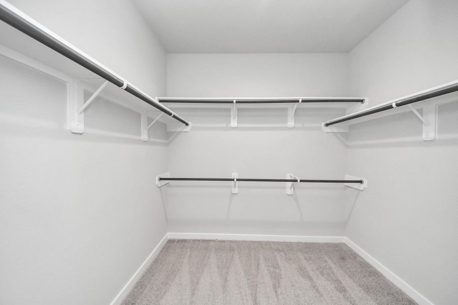 Walk-in closet that epitomizes luxury and practicality. This generously sized space features built-in shelving, offering abundant room for impeccable organization. High ceilings and recessed lighting create a bright and welcoming ambiance. Sample photo of completed home with similar floor plan. Actual colors and selections may vary. Walk-in closet that epitomizes luxury and practicality. This generously sized space features built-in shelving, offering abundant room for impeccable organization. High ceilings and recessed lighting create a bright and welcoming ambiance. Sample photo of completed home with similar floor plan. Actual colors and selections may vary.