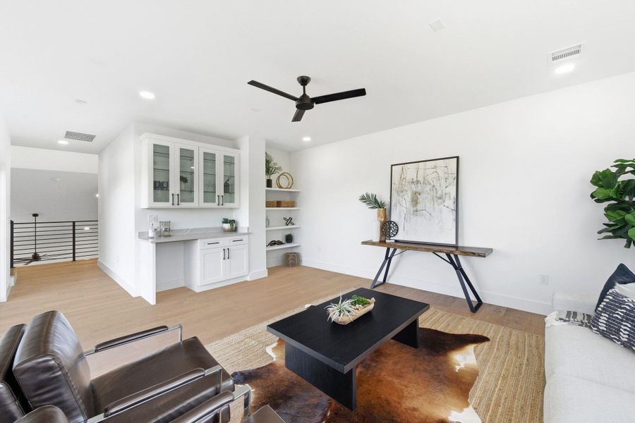 Flex space area off of upstairs bedrooms with private deck and tree top views  light wood-style floors, a ceiling fan, recessed lighting and dry bar