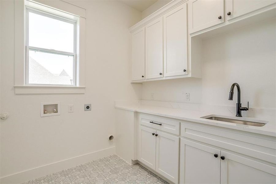 Laundry room with cabinet space, washer hookup, electric dryer hookup, and baseboards