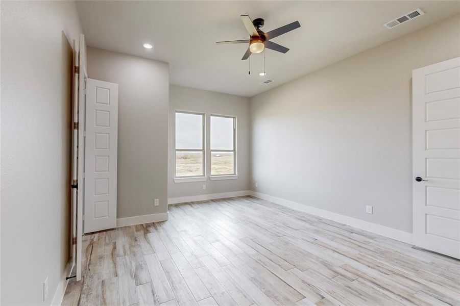 Spare room with light hardwood / wood-style floors and ceiling fan