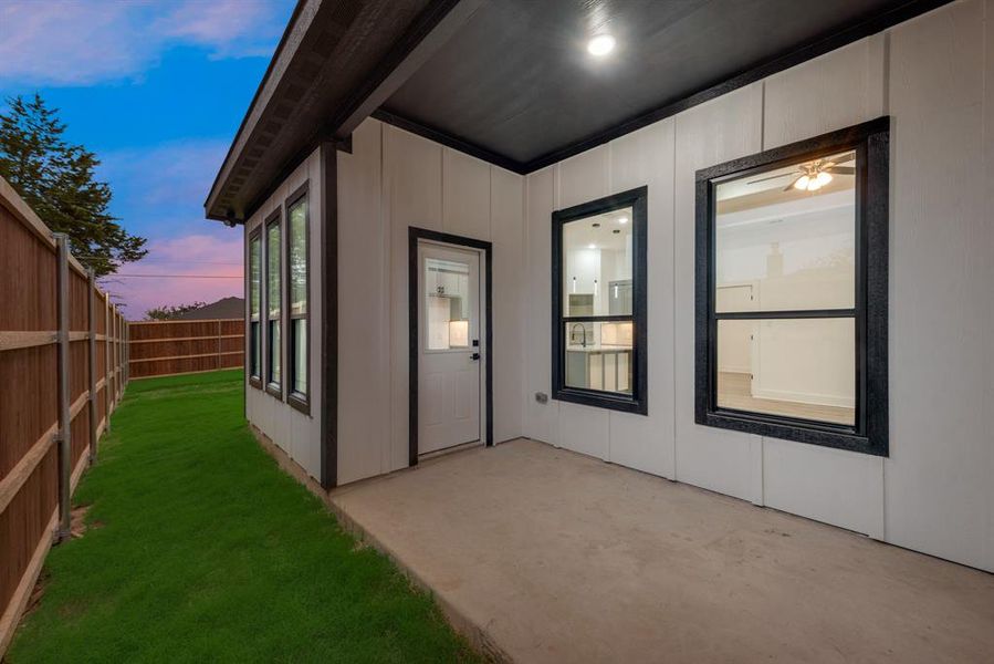 Exterior entry at dusk with a patio and a lawn