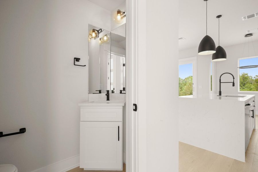 Bathroom with vanity, healthy amount of natural light, and light wood finished floors Bathroom with vanity, healthy amount of natural light, and light wood finished floors