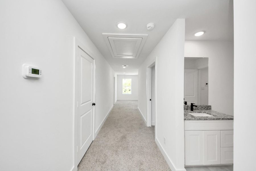 Primary Walk-In Closet – Spacious walk-in closet with built-in shelving, abundant hanging space, and organized storage.