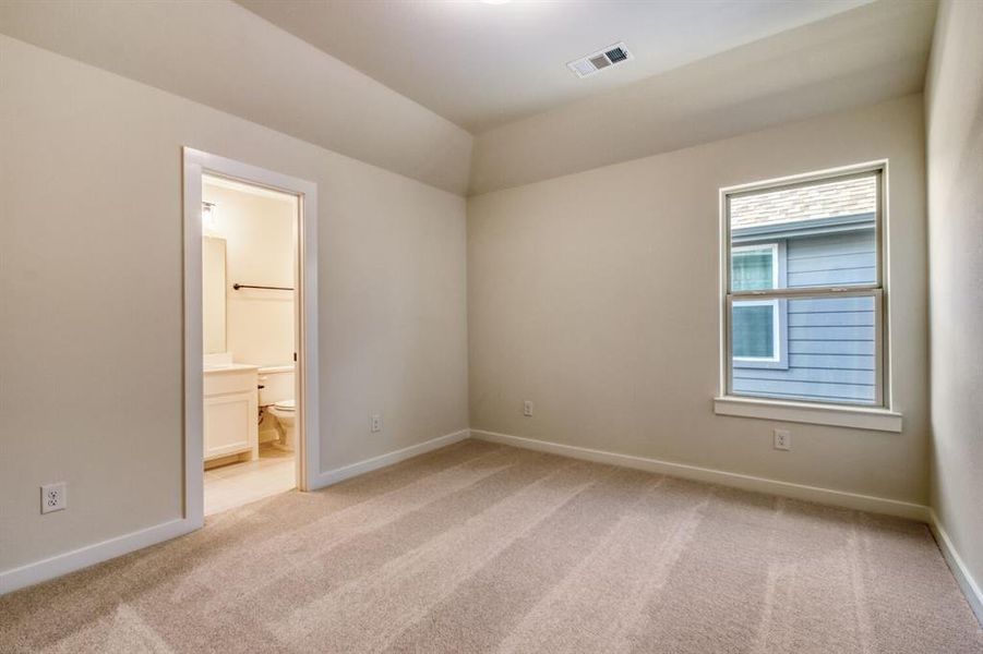 Unfurnished bedroom featuring light colored carpet and ensuite bath Unfurnished bedroom featuring light colored carpet and ensuite bath
