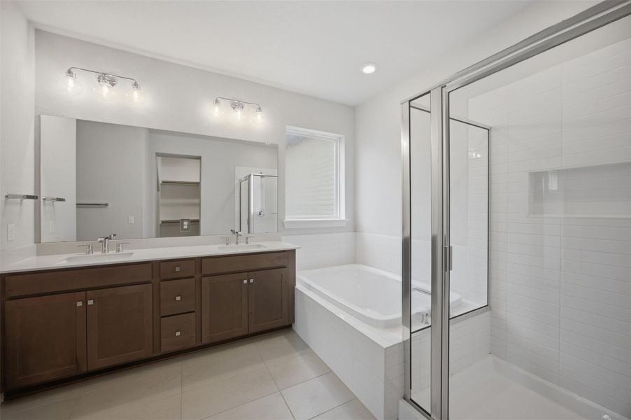 A well-appointed primary bathroom features a dual vanity, a soaking tub, and a separate glass-enclosed shower.