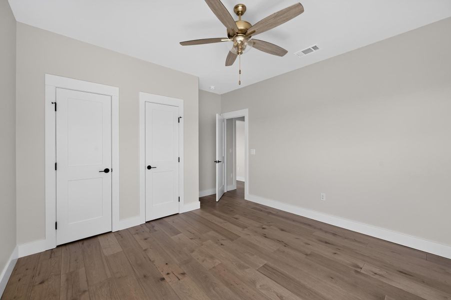 Rich hardwood flooring pairs with clean trim to elevate this versatile bedroom.