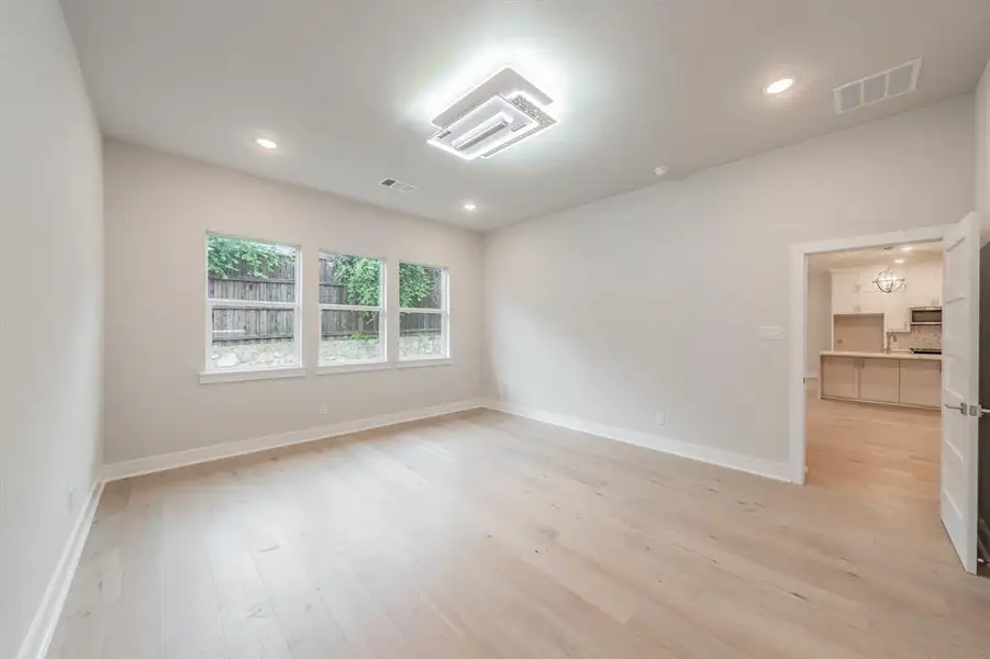 Empty room with light wood finished floors and recessed lighting