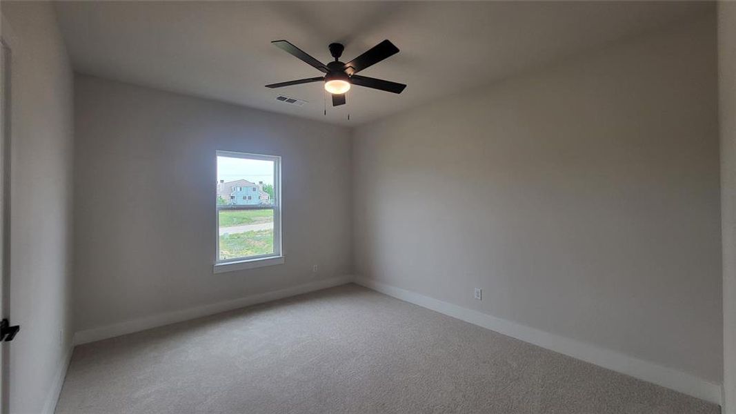 Spare room with ceiling fan, carpet floors, and baseboards
