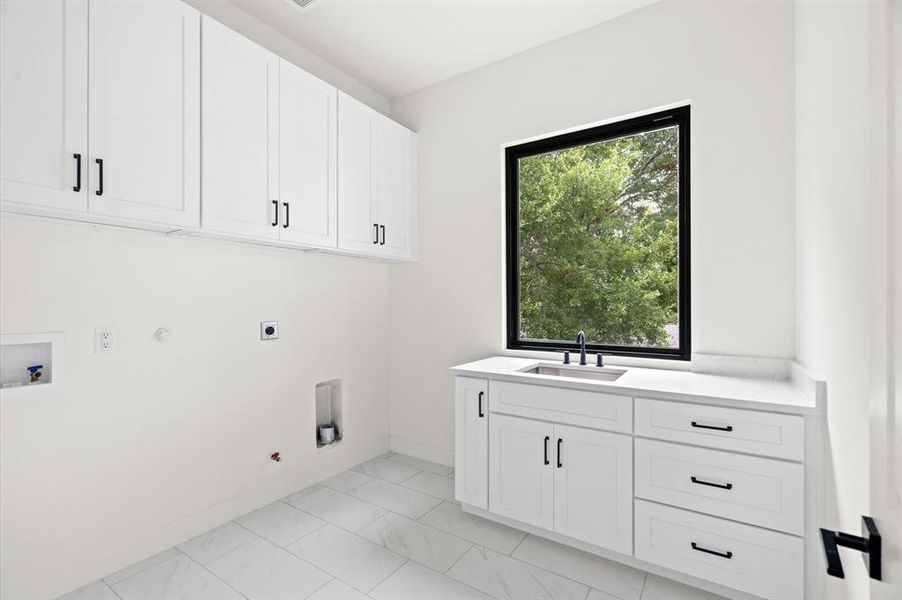 Second floor laundry room with cabinets and a sink.