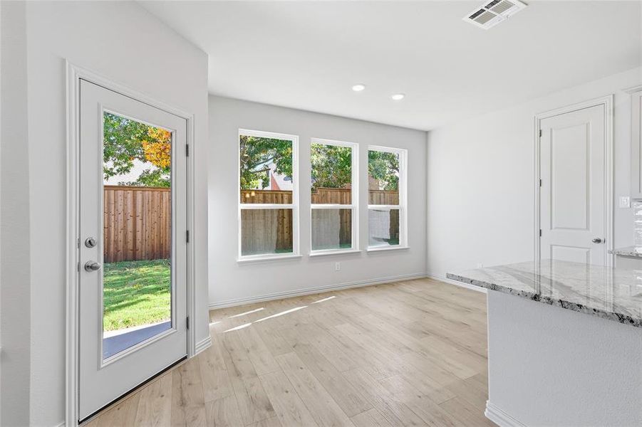 Unfurnished dining area with light wood-style floors and baseboards