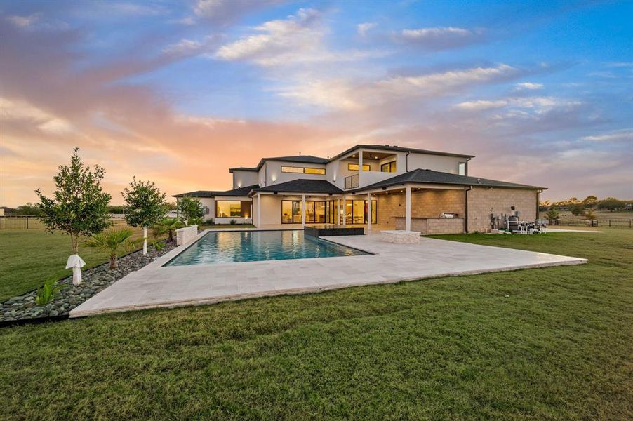 Stunning twilight view of the home with pool and outdoor living area. Stunning twilight view of the home with pool and outdoor living area.