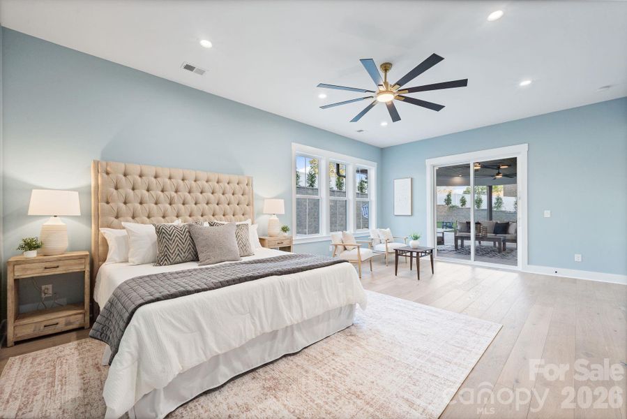 Expansive main level primary suite opens to covered back patio