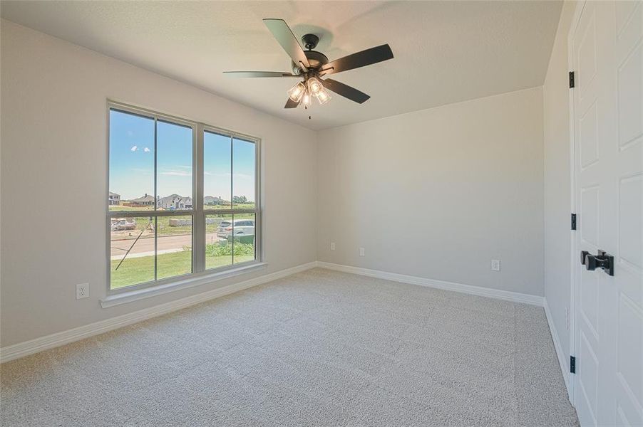 Unfurnished room with light carpet, a ceiling fan, and a residential view