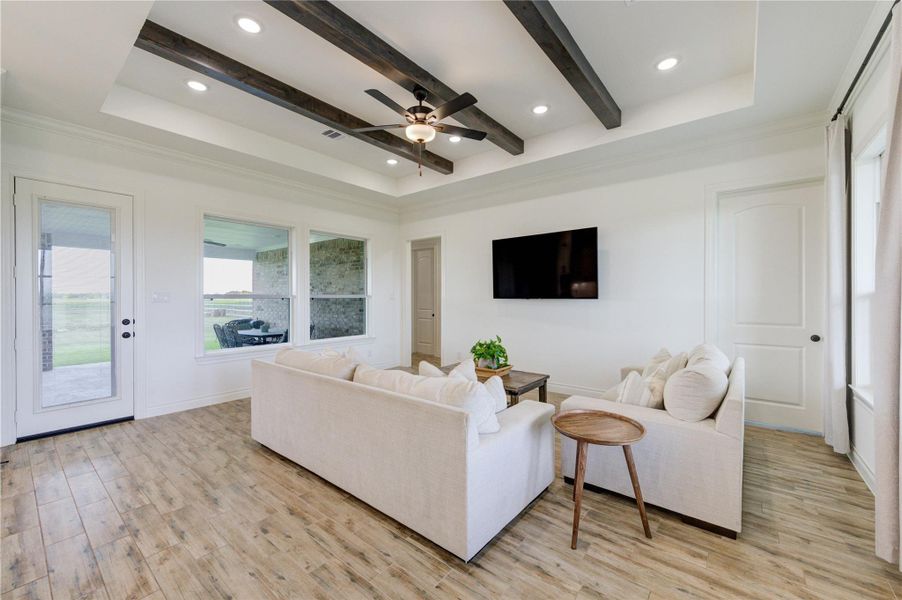 Spacious living room with beamed ceiling and natural light from large windows