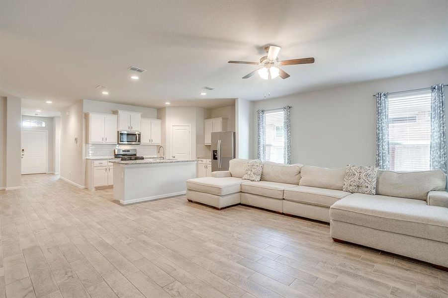 Living area featuring light wood-style flooring, recessed lighting, and a ceiling fan