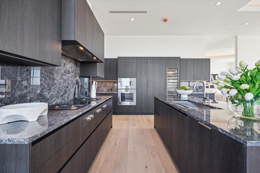 The kitchen is a perfect blend of high end finishes and clean lines. The sleek custom Eggersman cabinetry conceals the Gaggenau fridge, freezer and dishwasher. The cooktop has both gas and induction capability. The kitchen is a perfect blend of high end finishes and clean lines. The sleek custom Eggersman cabinetry conceals the Gaggenau fridge, freezer and dishwasher. The cooktop has both gas and induction capability.