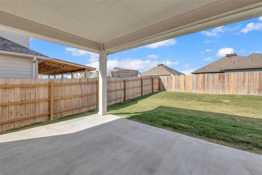 Fenced backyard with a patio area Fenced backyard with a patio area