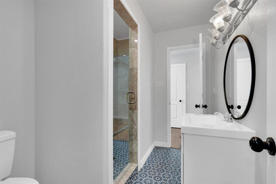 Ensuite upstairs Bathroom featuring toilet, a shower stall, vanity, and baseboards