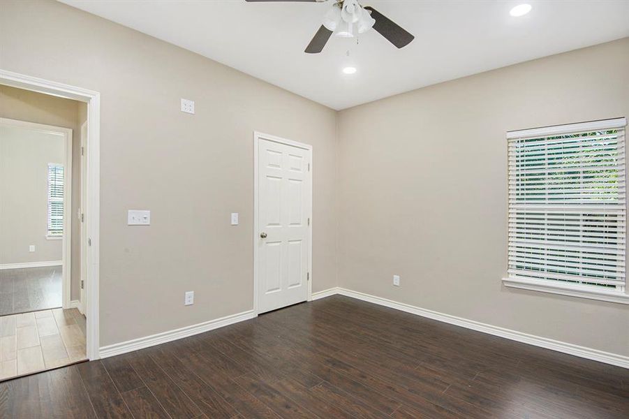 Empty room featuring dark wood-style flooring, ceiling fan, and recessed lighting
