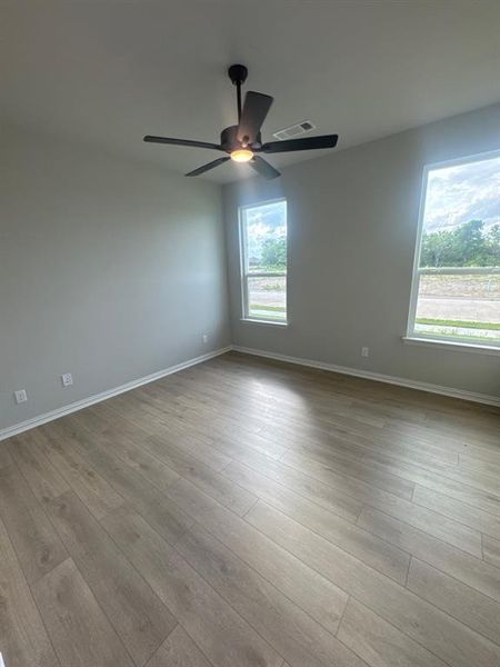 Room featuring light wood-finish flooring, light grey walls, and white trim