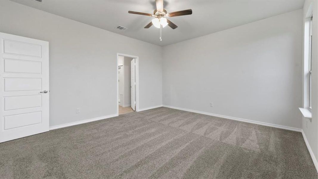 Carpeted empty room featuring baseboards and a ceiling fan Carpeted empty room featuring baseboards and a ceiling fan