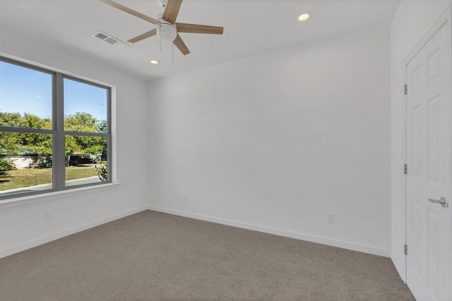 Carpeted spare room with a ceiling fan and recessed lighting