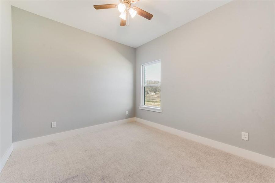 Spare room featuring ceiling fan and carpet